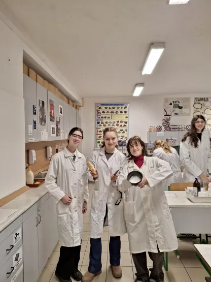 Skupina studentek v laboratorních pláštích v chemické učebně