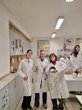 Skupina studentek v laboratorních pláštích v chemické učebně